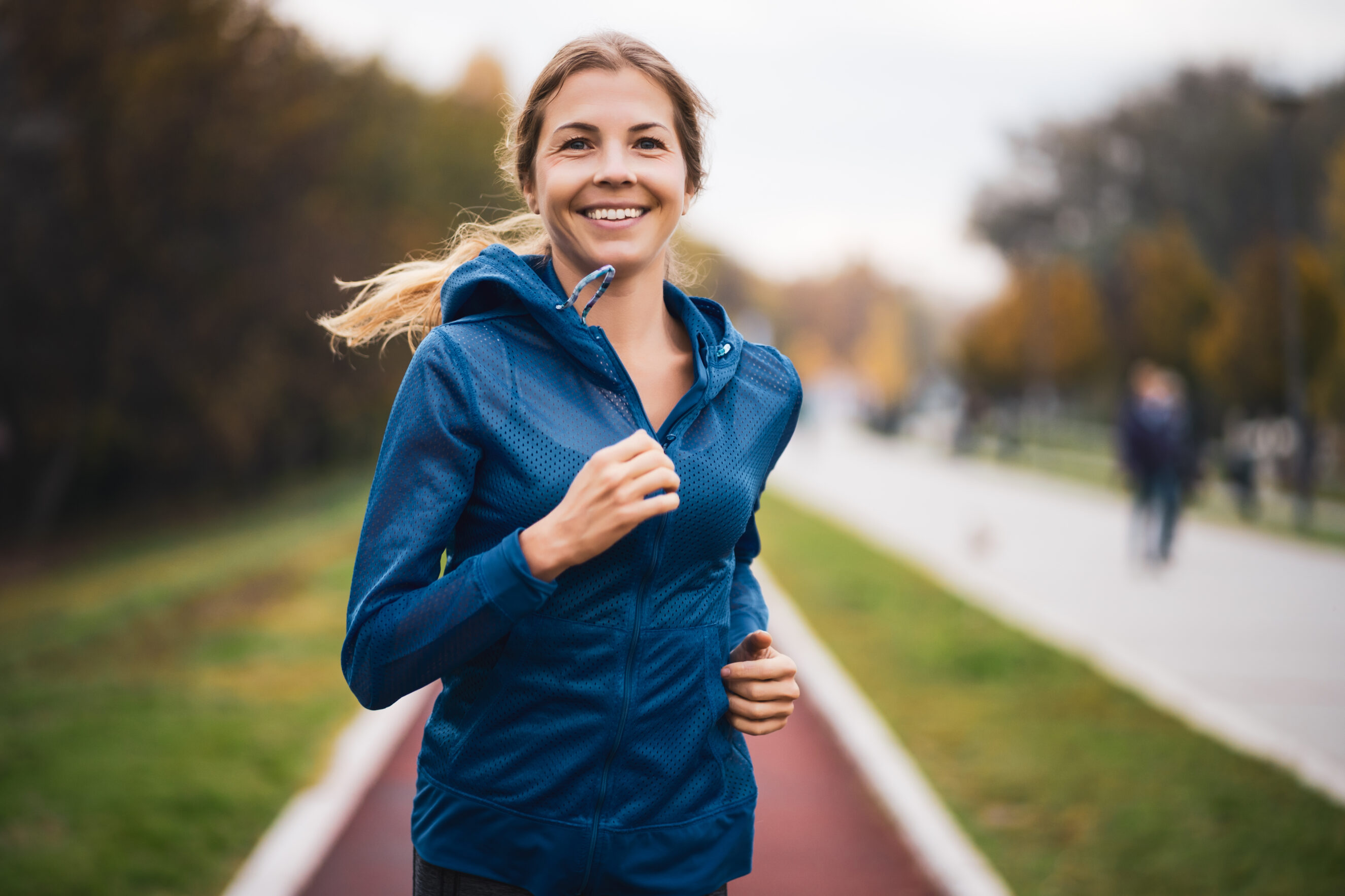 Active woman running outside in a park